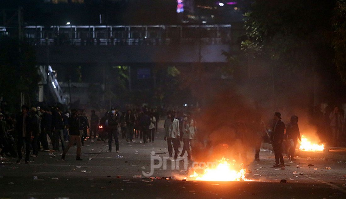 Petugas keamanan saat bentrok dengan pendemo di depan Gedung DPR, Jakarta, Selasa (24/9). - JPNN.com