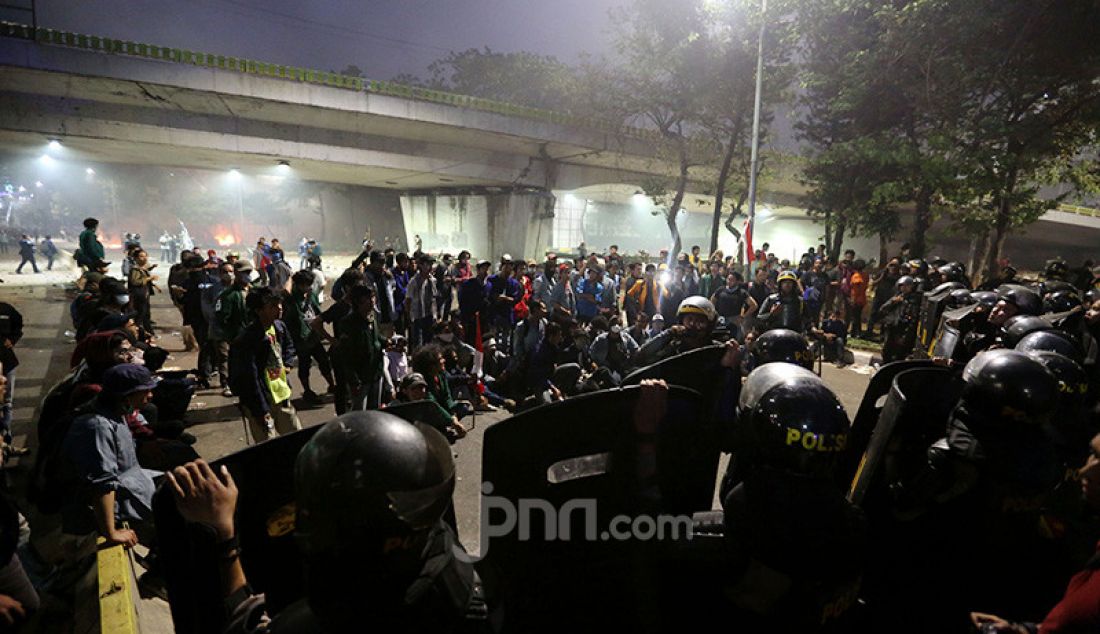 Petugas keamanan saat bentrok dengan pendemo di depan Gedung DPR, Jakarta, Selasa (24/9). - JPNN.com