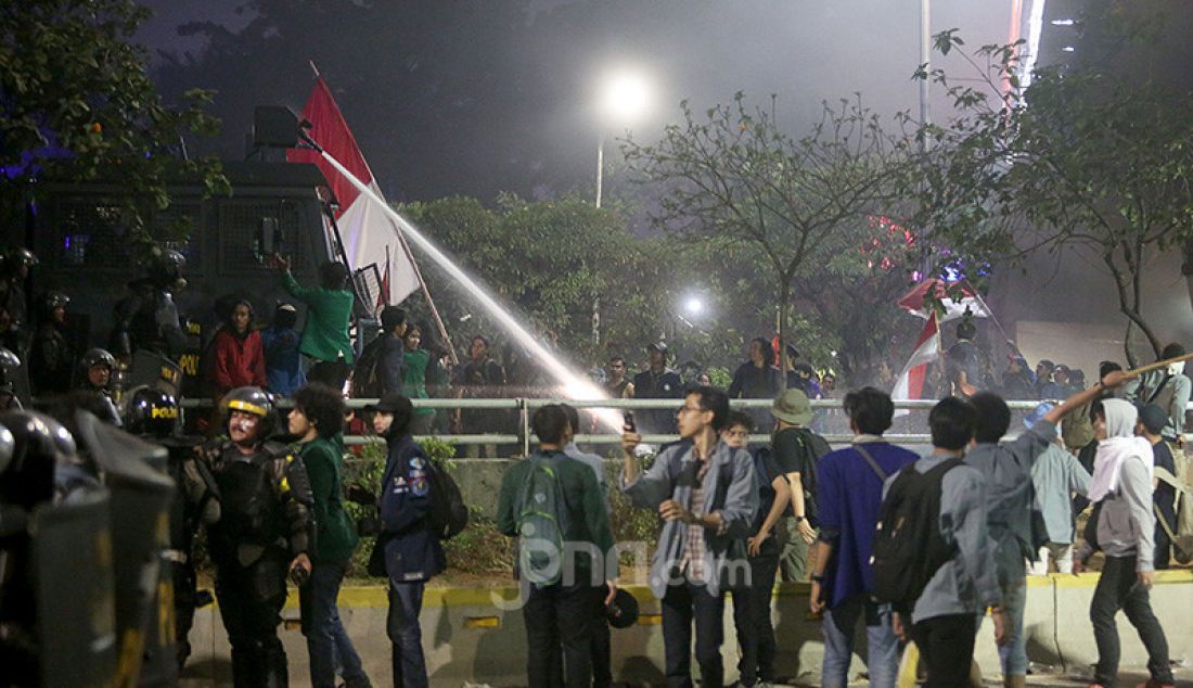 Petugas keamanan saat bentrok dengan pendemo di depan Gedung DPR, Jakarta, Selasa (24/9). - JPNN.com