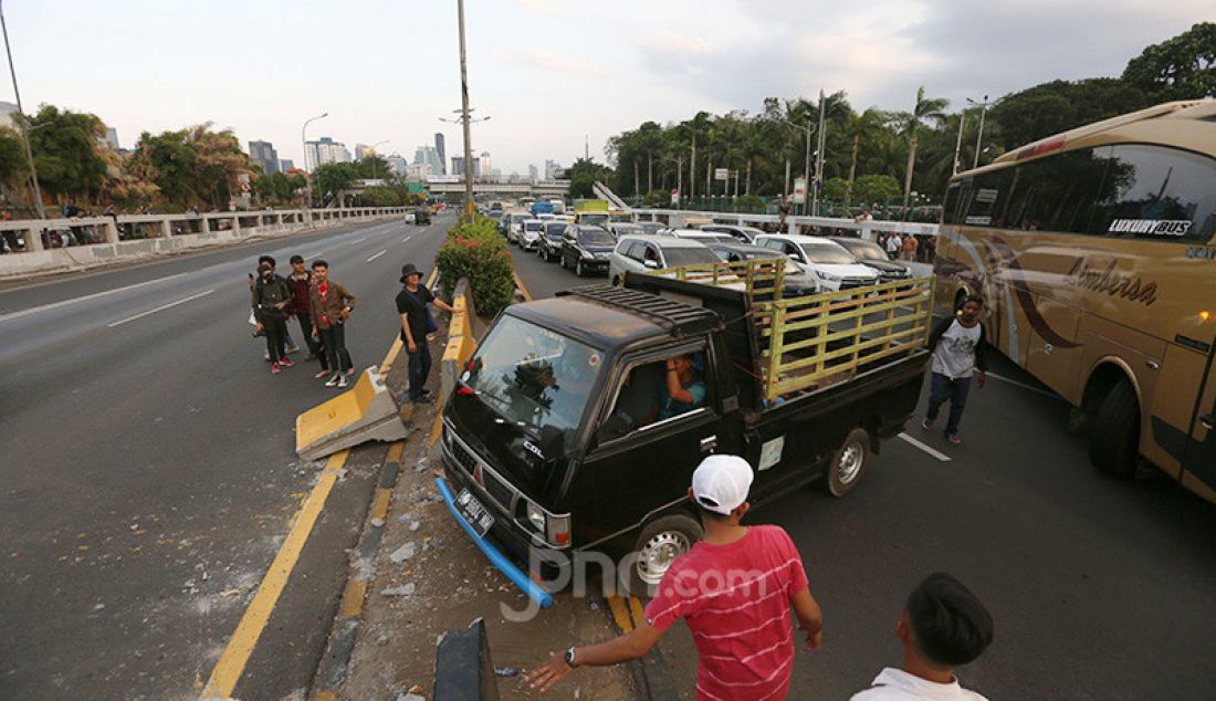 Sejumlah kendaraan berputar balik di depan gedung DPR, Jakarta, Senin (30/9). Jalan Tol Dalam Kota yang menuju Slipi ditutup karena bentrok antara Mahasiswa dan Pelajar dengan Aparat Kepolisian. - JPNN.com