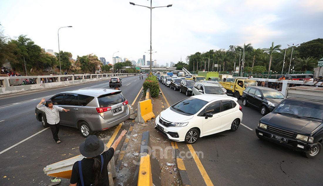 Sejumlah kendaraan berputar balik di depan gedung DPR, Jakarta, Senin (30/9). Jalan Tol Dalam Kota yang menuju Slipi ditutup karena bentrok antara Mahasiswa dan Pelajar dengan Aparat Kepolisian. - JPNN.com