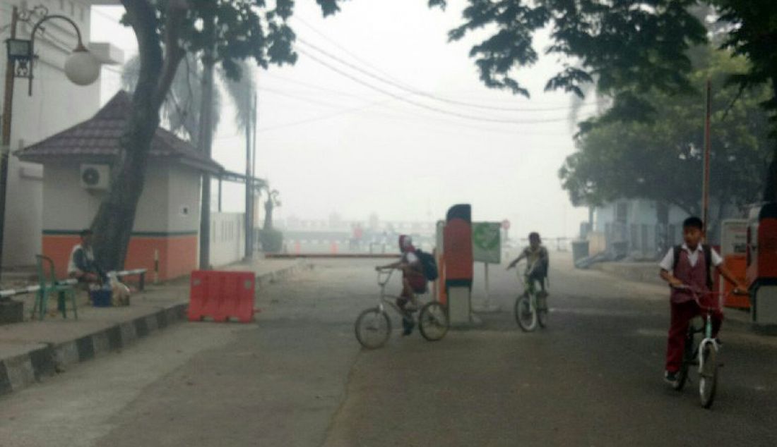 Siswa SD pulang setelah sekolah memutuskan meliburkan siswa karena kabut asap pekat membuat kualitas udara Kota Palembang memburuk hingga tingkat membahayakan, Senin (14/10). - JPNN.com