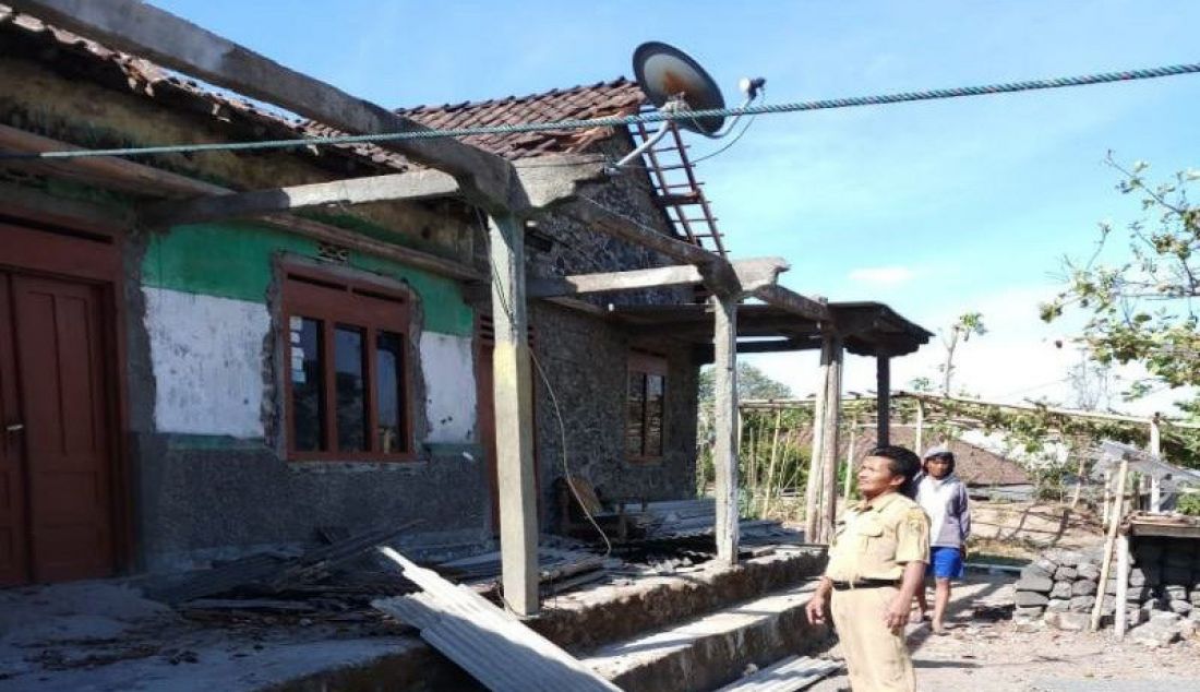 Seorang petugas pemerintah desa saat melakukan pengecekan rumah warga yang rusak akibat diterjang angin puting beliung, di Desa Jrakah Kecamatan Selo, Kabupaten Boyolali, Senin (21/10) - JPNN.com