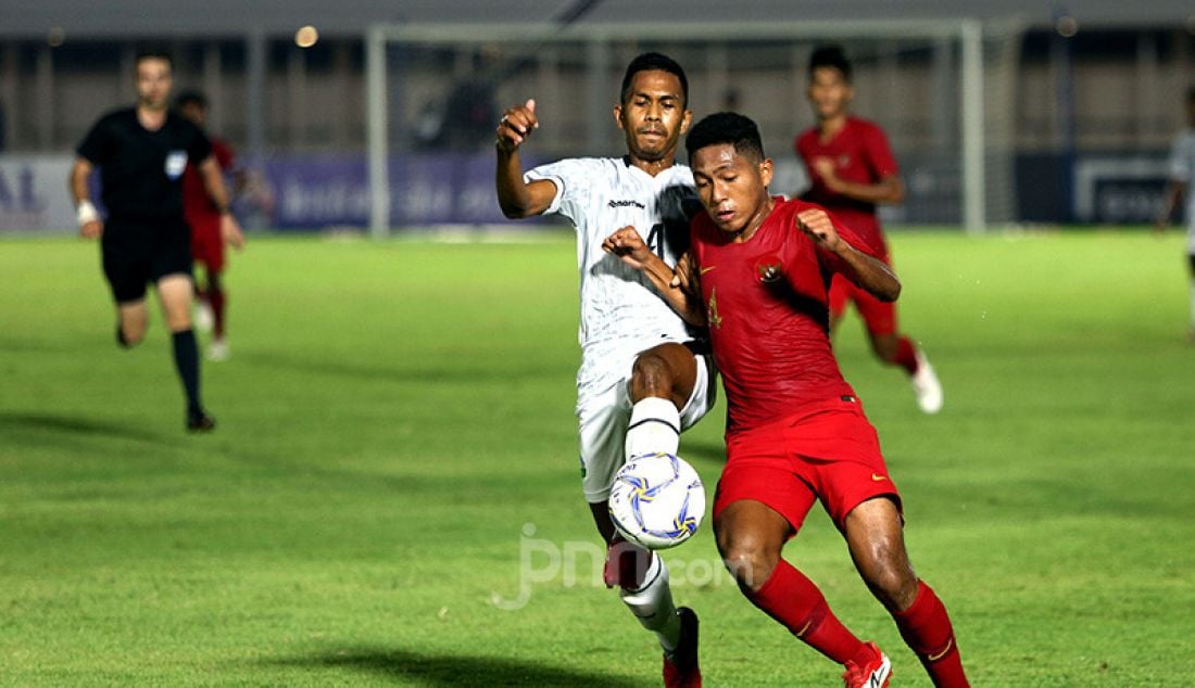Pemain U-19 Indonesia Muhammad Fajar Fathur berduel dengan pemai U-19 Timor Leste Orcelio Nobelito Moises pada Kualifikasi AFC U-19 Championship 2020 di Stadion Madya, Jakarta, Rabu (6/11). U-19 Indonesia menang atas lawannya dengan skor 3-1. - JPNN.com