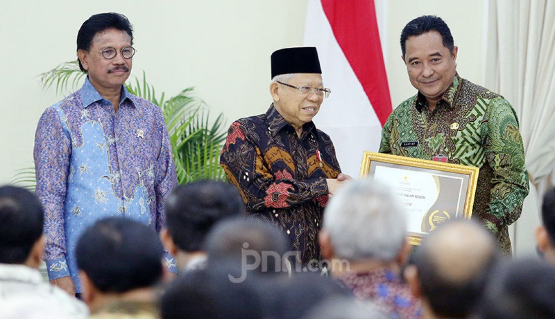 Wapres Ma'ruf Amin memberikan penghargaan kepada Plt Dirjen Politik dan Pemerintahan Umum Kementerian Dalam Negeri Bahtiar pada acara Penganugerahan Keterbukaan Informasi Publik Tahun 2019 di Istana Wapres, Jakarta, Kamis (21/11). Kemendagri sebagai badan publik Informatif. - JPNN.com