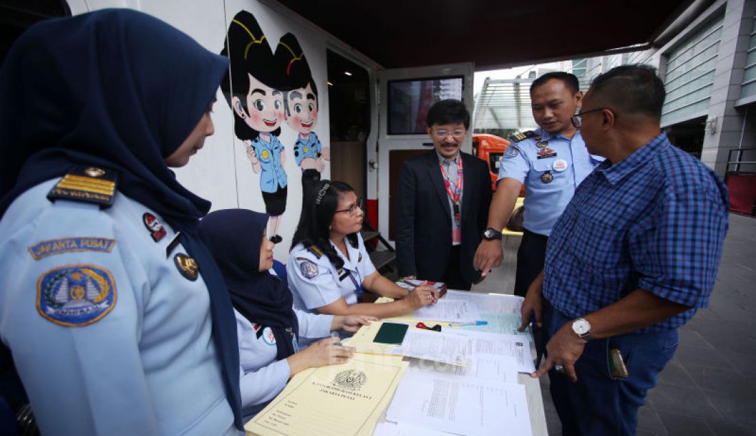Direktur Smartfren Marco Sumampow (ketiga kanan) dan Kepala Seksi Infokim Kantor Imigrasi Kelas 1 Non TPI Jakarta Pusat Alvian Bayu (kedua kanan) berbincang dengan masyarakat yang sedang mengurus passport di Jakarta. - JPNN.com