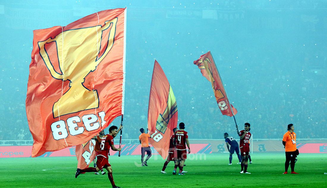 Sejumlah pemain Persija Jakarta membawa bendera berlambang piala usai mengalahkan Persipura Jayapura 1-0 pada Liga 1 2019 di Stadion Utama Gelora Bung Karno, Jakarta, Kamis (28/11). - JPNN.com