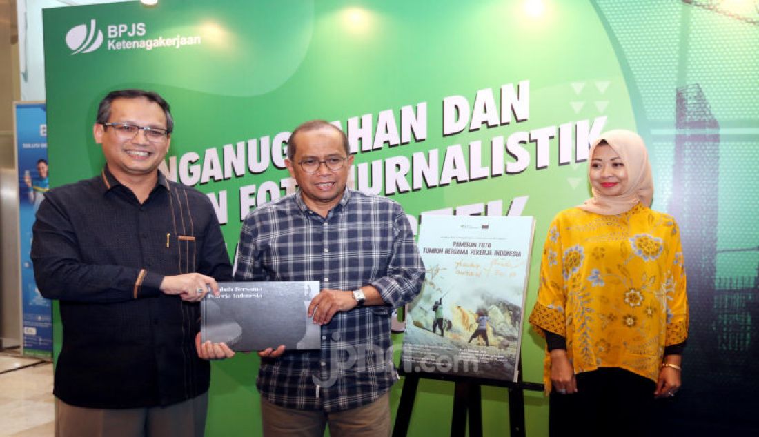 Direktur Umum & SDM BPJAMSOSTEK, Naufal Mahfudz (kiri), menyerahkan buku hasil karya foto jurnalistik bertema ‘Tumbuh Maju Bersama Pekerja Indonesia’ kepada Ketua Dewan Pengawas Guntur Witjaksono (tengah), disaksikan Direktur Keuangan BPJAMSOSTEK Evi Afiatin (kanan), usai mengumumkan pemenang lomba foto sekaligus pameran di lobi BPJAMSOSTEK, Jakarta, Jumat (6/12). - JPNN.com
