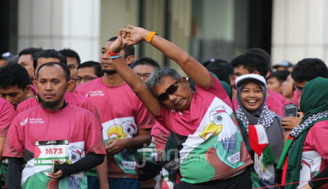 Peserta Run for Palestine sedang melakukan pemanasan. Sebanyak 1100 peserta berlari dari KPPTI ke arah bundaran HI kemudian kembali lagi ke gedung Indosat untuk menyuarakan kemanusiaan. - JPNN.com