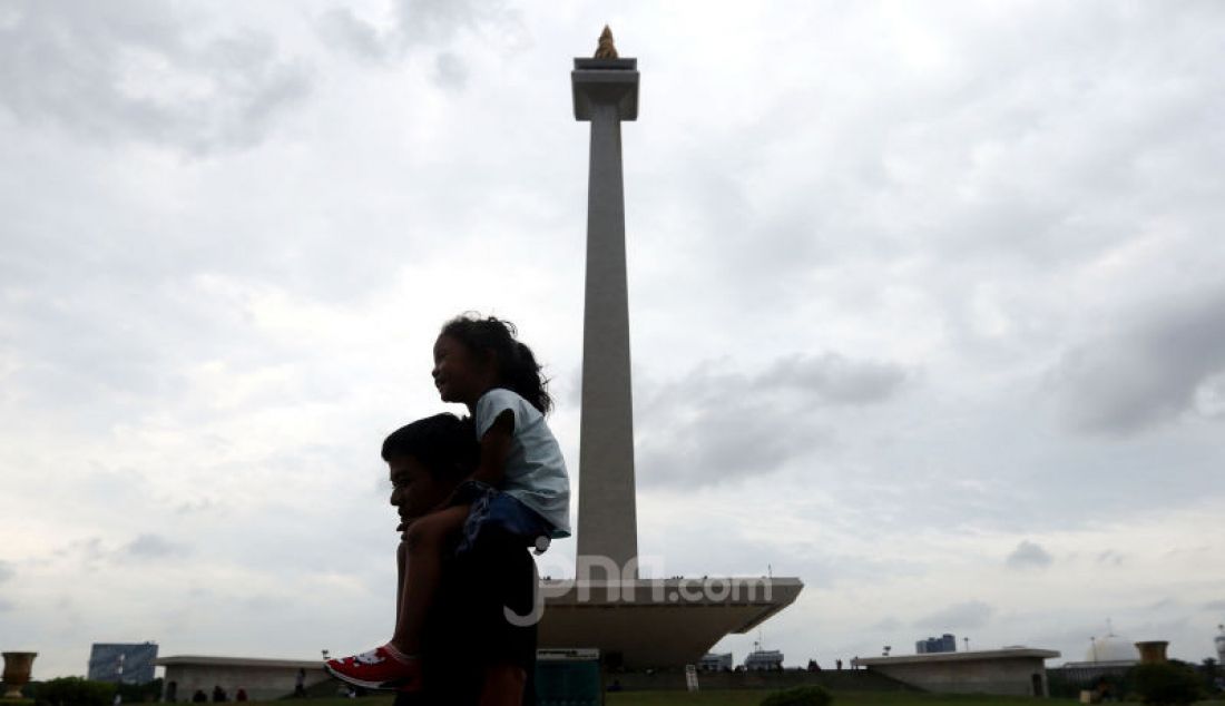 Warga menikmati suasana di Monas, Jakarta, Selasa (31/12). - JPNN.com