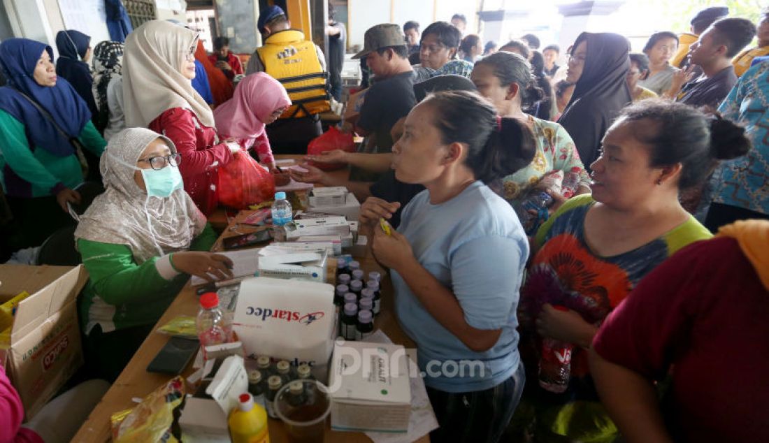 Petugas melayani pengungsi yang terkena banjir di Ciledug Indah, Tangerang, Kamis (2/1). - JPNN.com