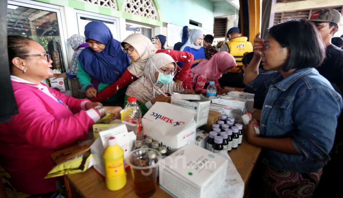 Petugas melayani pengungsi yang terkena banjir di Ciledug Indah, Tangerang, Kamis (2/1). - JPNN.com