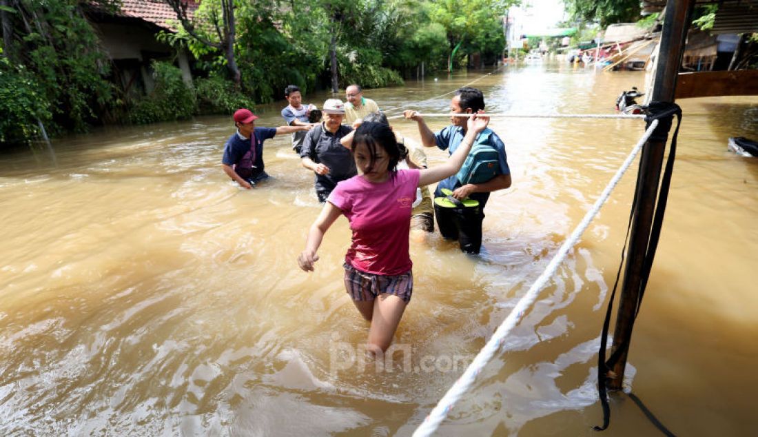 Warga berusaha melewati banjir di Ciledug Indah, Tangerang, Kamis (2/1). - JPNN.com