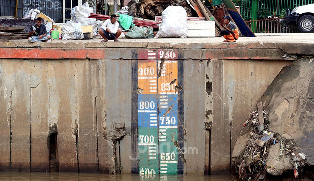 Warga memancing di tepian pintu air Manggarai, Jakarta, Rabu (8/1). Volume air di pintu air Manggarai terpantau dalam keadaan normal atau 600 cm. - JPNN.com