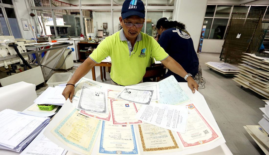 Petugas dari Kantor ANRI (Arsip Nasional Republik Indonesia), yang tergabung dalam Tim Rescue Arsip menyelesaikan proses restorasi arsip milik warga terdampak banjir, Jakarta, Rabu (8/1). Layanan restorasi arsip ini gratis tidak dipungut biaya. - JPNN.com