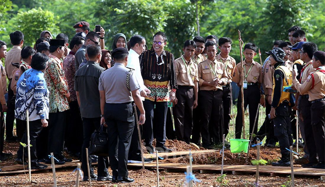 Ketua HPN 2020 Auri Jaya mendampingi Presiden Joko Widodo melihat salah satu tanaman di area Hutan Kota Tropis, Sabtu (8/2). - JPNN.com