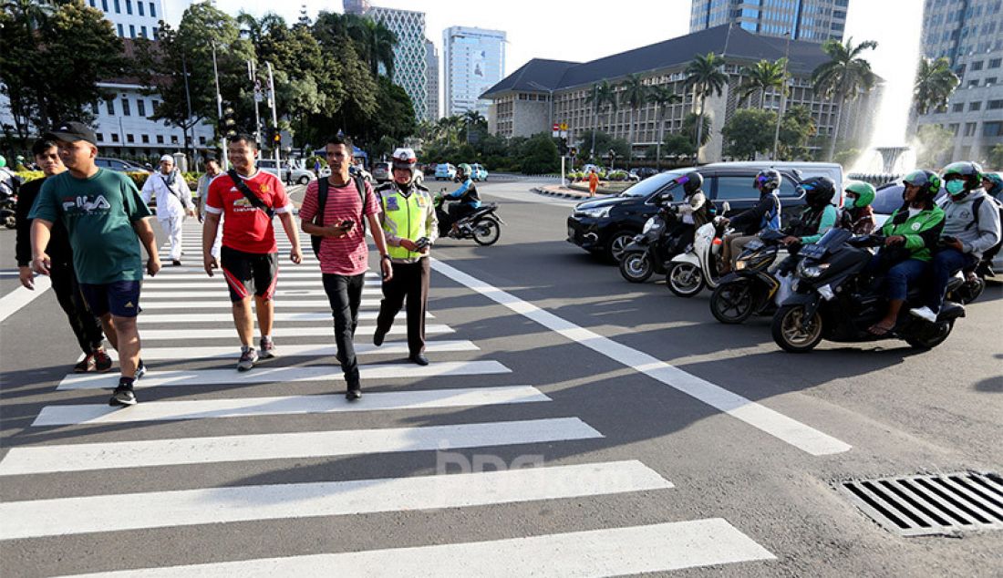 Pejalan kaki saat menyeberang jalan menggunakan Zebra Cross di Jalan Medan Merdeka Selatan, Jakarta, Jumat (21/2). - JPNN.com