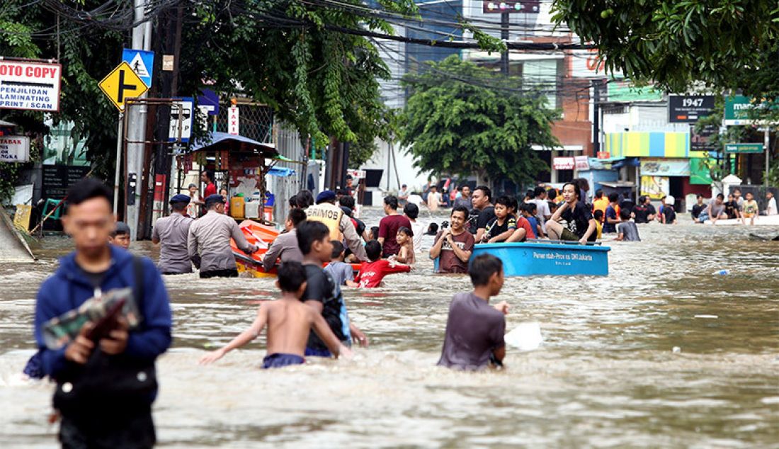 Warga berusaha melewati banjir di kawasan Benhil, Jakarta, Selasa (25/2). Hujan deras mengguyur kota Jakarta pada dini hari membuat sebagian Jakarta mengalami banjir. - JPNN.com