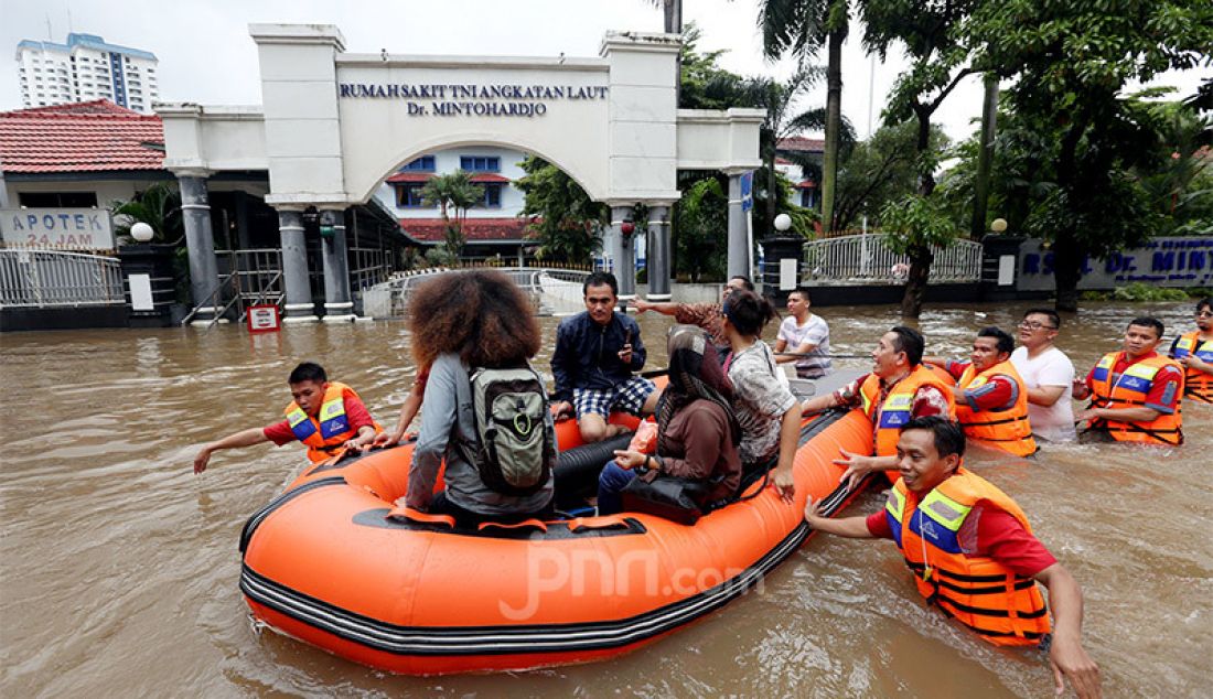 Warga berusaha melewati banjir di kawasan Benhil, Jakarta, Selasa (25/2). Hujan deras mengguyur kota Jakarta pada dini hari membuat sebagian Jakarta mengalami banjir. - JPNN.com