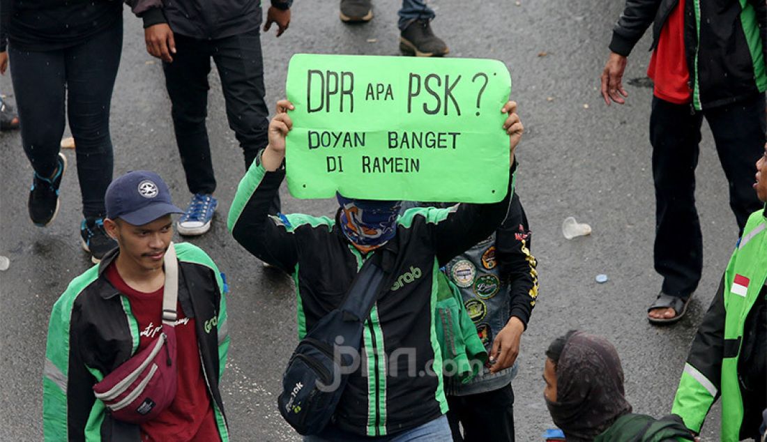 Massa ojek online menggelar aksi di depan Gedung DPR, Jakarta, Jumat (28/2). Mereka menuntut pernyataan pimpinan Komisi V DPR Nurhayati Monoarfa terkait pernyataan soal pembatasan motor. - JPNN.com