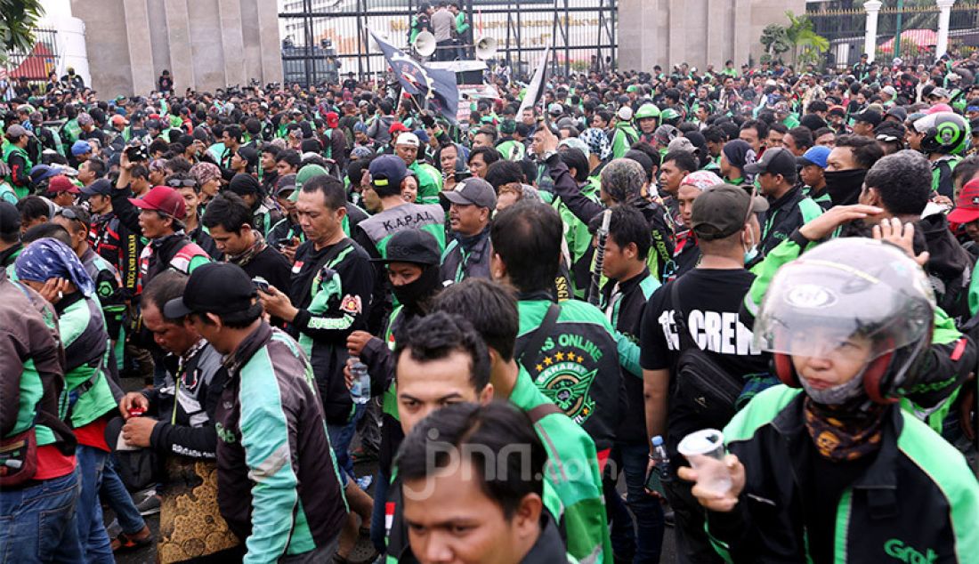 Massa ojek online menggelar aksi di depan Gedung DPR, Jakarta, Jumat (28/2). Mereka menuntut pernyataan pimpinan Komisi V DPR Nurhayati Monoarfa terkait pernyataan soal pembatasan motor. - JPNN.com