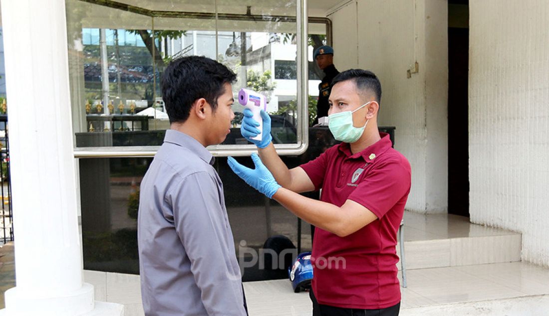 Personil Paspampres melakukan pengecekan suhu tubuh tamu yang datang dan hendak memasuki Istana Negara, Jakarta, Selasa (3/3). - JPNN.com