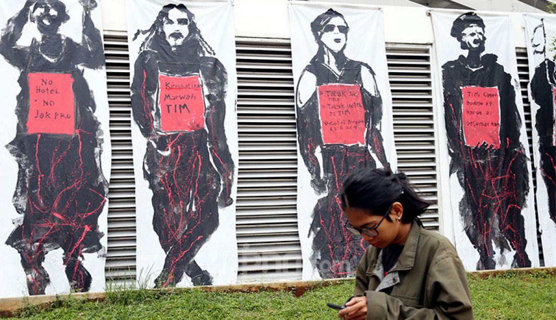 Seorang warga melintas di depan Mural Save TIM di Taman Ismail Marzuki, Jakarta, Selasa (3/3). - JPNN.com