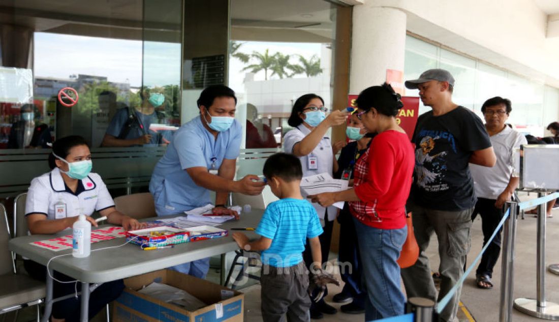 Petugas memeriksa suhu tubuh pengunjung sebelum masuk Rumah Sakit Siloam, Jakarta, Sabtu (7/3). RS Siloam menyediakan fasilitas tenda isolasi sementara, ruangan dekontaminasi, pengecekan suhu tubuh guna mengantisipasi penyebaran virus corona COVID-19. - JPNN.com