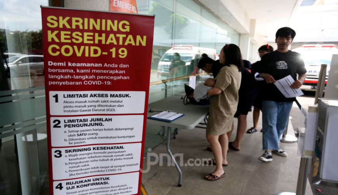 Pengunjung mengisi formulir pernyataan kesehatan sebelum memasuki Rumah Sakit Siloam, Jakarta, Sabtu (7/3). - JPNN.com