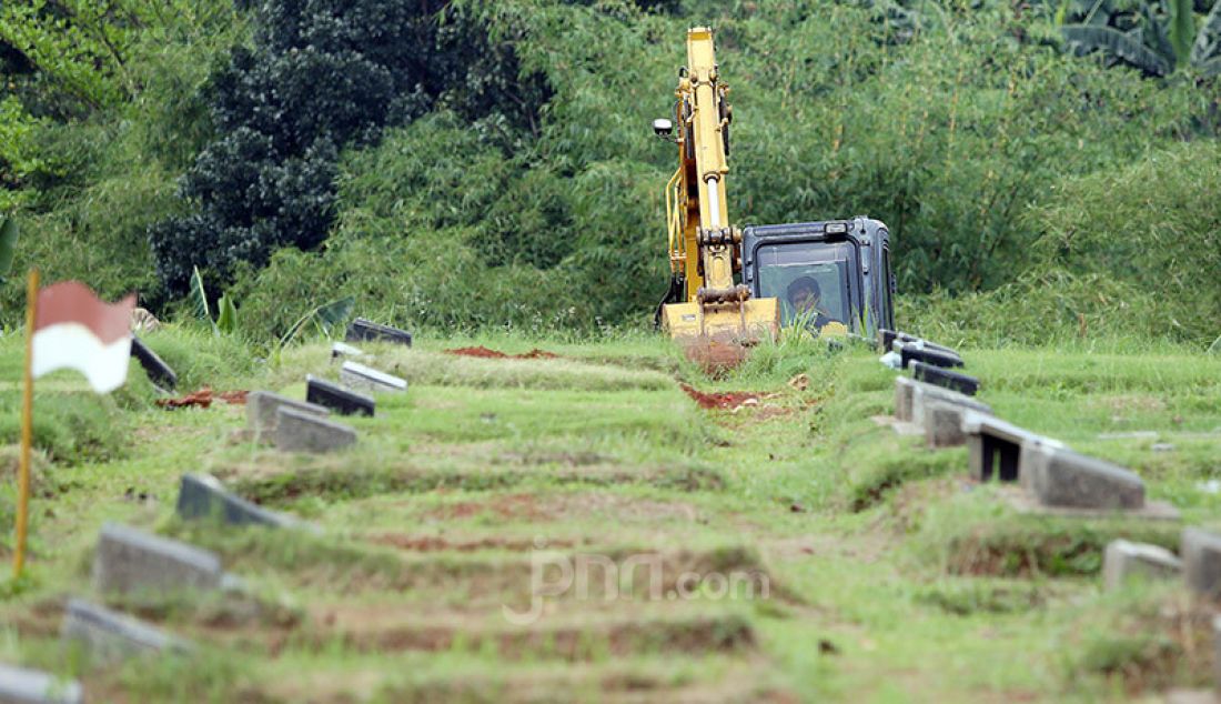 Petugas menguruk tanah untuk melebarkan lahan pemakaman bagi jenazah korban Covid-19 di TPU Pondok Ranggon, Cipayung, Jakarta Timur, Rabu (1/4). - JPNN.com