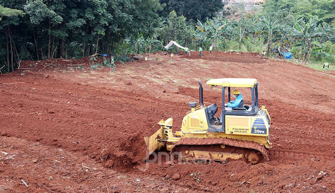Petugas menguruk tanah untuk melebarkan lahan pemakaman bagi jenazah korban Covid-19 di TPU Pondok Ranggon, Cipayung, Jakarta Timur, Rabu (1/4). - JPNN.com