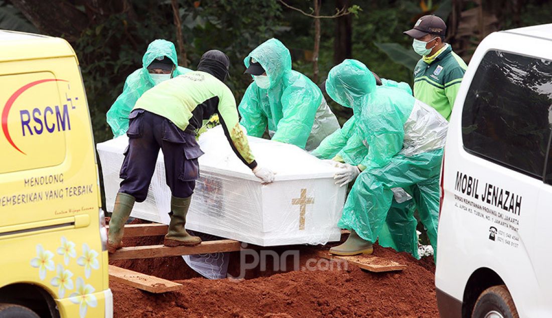 Petugas membawa jenazah korban Covid-19 untuk dimakamkan di TPU Pondok Ranggon, Cipayung, Jakarta, Rabu (1/4). Selain TPU Pondok Rangon, TPU Tegal Alur juga menjadi rujukkan tempat pemakaman korban Covid-19. - JPNN.com