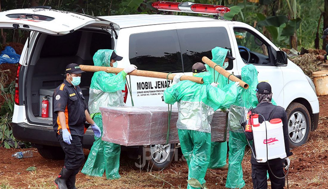 Petugas membawa jenazah korban Covid-19 untuk dimakamkan di TPU Pondok Ranggon, Cipayung, Jakarta, Rabu (1/4). Selain TPU Pondok Rangon, TPU Tegal Alur juga menjadi rujukkan tempat pemakaman korban Covid-19. - JPNN.com