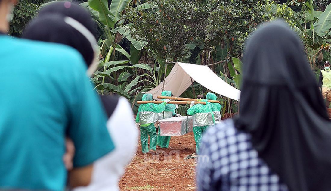Kerabat menghadiri pemakaman jenazah korban Covid-19 di TPU Pondok Ranggon, Cipayung, Jakarta Timur, Rabu (1/4). Petugas membatasi kerabat korban yang menghadiri pemakaman. - JPNN.com
