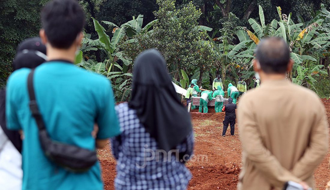 Kerabat menghadiri pemakaman jenazah korban Covid-19 di TPU Pondok Ranggon, Cipayung, Jakarta Timur, Rabu (1/4). Petugas membatasi kerabat korban yang menghadiri pemakaman. - JPNN.com
