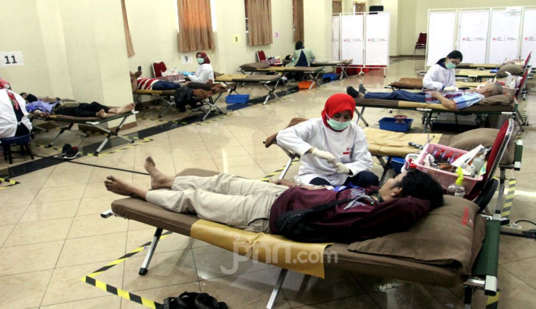 Sejumlah relawan sedang melakukan donor darah sekaligus mengedukasi masyarakat tentang aktivitas donor darah tetap aman di tengah kondisi wabah virus Covid-19 yang berlangsung di kantor PMI DKI Jakarta, Selasa (31/3). - JPNN.com