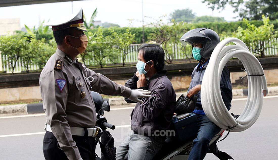 Aparat Polri bersama Dishub memeriksa pengendara roda dua dan empat di Jalan Ciputat Raya, Jakarta, Jumat (10/4). Pemeriksaan bertujuan menghimbau pengendara untuk menggunakan masker selama PSBB. - JPNN.com