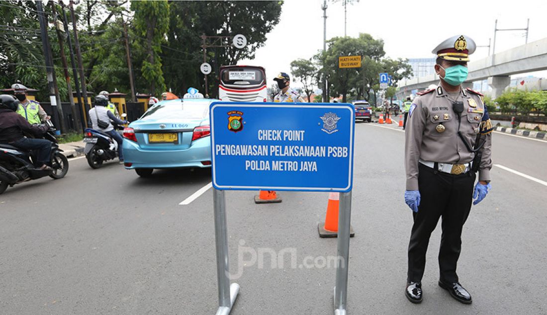 Aparat Polri bersama Dishub memeriksa pengendara roda dua dan empat di Jalan Ciputat Raya, Jakarta, Jumat (10/4). Pemeriksaan bertujuan menghimbau pengendara untuk menggunakan masker selama PSBB. - JPNN.com