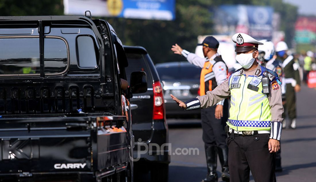 Petugas gabungan melakukan pemeriksaan kendaraan di Pintu Keluar Tol Baranangsiang, Bogor, Jawa Barat, Rabu (15/4). Pemeriksaan bertujuan menghimbau pengendara untuk menggunakan masker dan posisi duduk sesuai PSBB. - JPNN.com