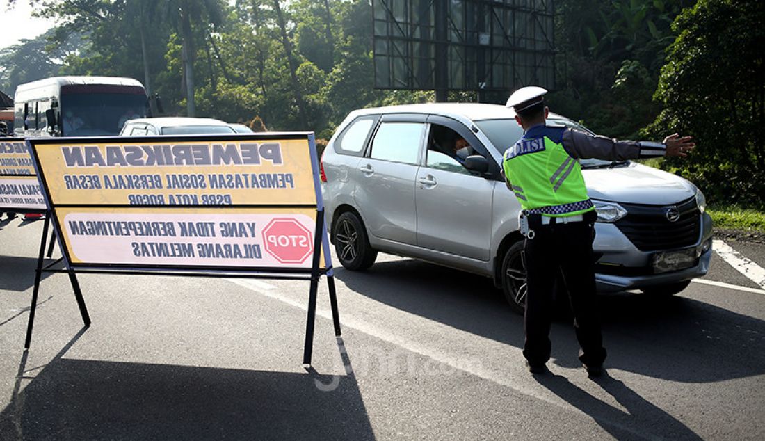 Petugas gabungan melakukan pemeriksaan kendaraan di Pintu Keluar Tol Baranangsiang, Bogor, Jawa Barat, Rabu (15/4). Pemeriksaan bertujuan menghimbau pengendara untuk menggunakan masker dan posisi duduk sesuai PSBB. - JPNN.com