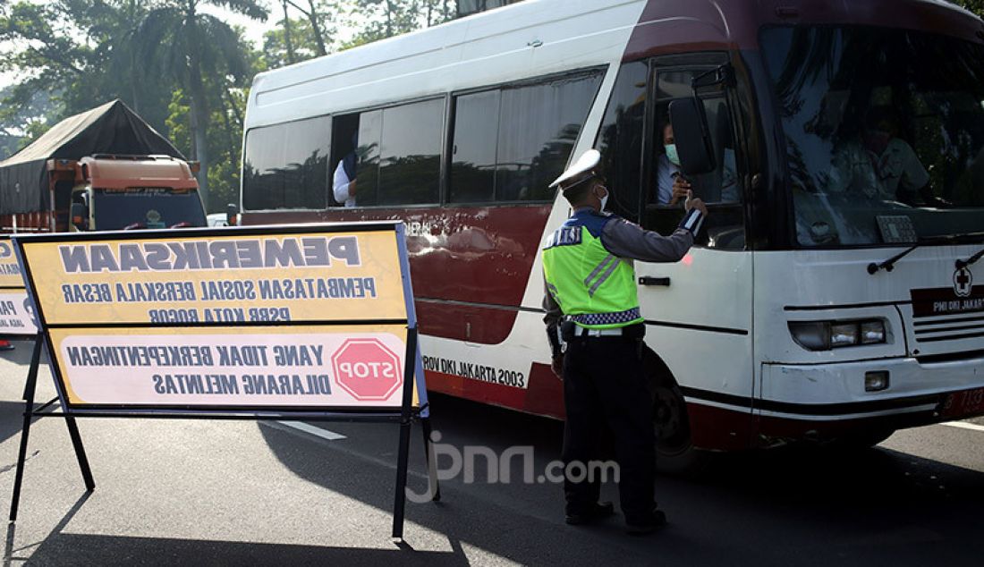 Petugas gabungan melakukan pemeriksaan kendaraan di Pintu Keluar Tol Baranangsiang, Bogor, Jawa Barat, Rabu (15/4). Pemeriksaan bertujuan menghimbau pengendara untuk menggunakan masker dan posisi duduk sesuai PSBB. - JPNN.com