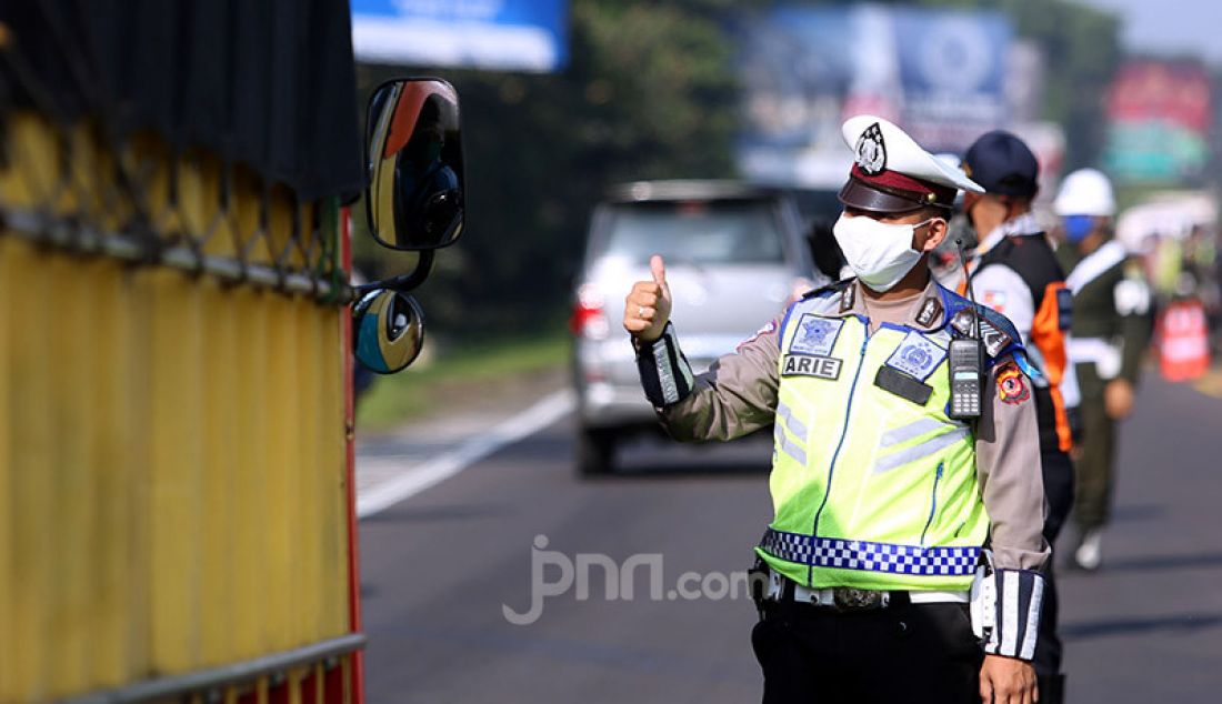 Petugas gabungan melakukan pemeriksaan kendaraan di Pintu Keluar Tol Baranangsiang, Bogor, Jawa Barat, Rabu (15/4). Pemeriksaan bertujuan menghimbau pengendara untuk menggunakan masker dan posisi duduk sesuai PSBB. - JPNN.com