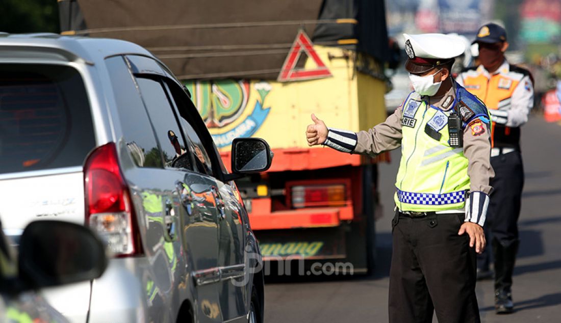 Petugas gabungan melakukan pemeriksaan kendaraan di Pintu Keluar Tol Baranangsiang, Bogor, Jawa Barat, Rabu (15/4). Pemeriksaan bertujuan menghimbau pengendara untuk menggunakan masker dan posisi duduk sesuai PSBB. - JPNN.com