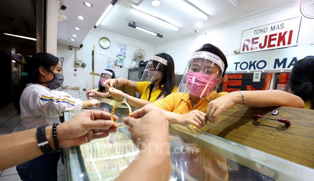 Pegawai toko menggunakan masker dan alat pelindung wajah (face shield) di toko emas Rejeki, Pasar Bogor, Senin (20/4). Penggunaan alat pelindung wajah tersebut sebagai upaya pencegahan penyebaran virus Corona (COVID-19). - JPNN.com