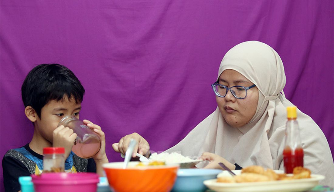Seorang anak saat berbuka puasa bersama ibunya di bulan suci Ramadhan 1441 H, Kabupaten Bogor, Kamis (7/5). Anak usia 5 tahun atau lebih sudah layak diperkenalkan untuk berpuasa dengan waktu minimal 4-5 jam dalam sehari. - JPNN.com