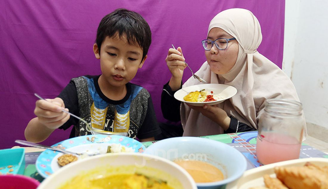 Seorang anak saat berbuka puasa bersama ibunya di bulan suci Ramadhan 1441 H, Kabupaten Bogor, Kamis (7/5). Anak usia 5 tahun atau lebih sudah layak diperkenalkan untuk berpuasa dengan waktu minimal 4-5 jam dalam sehari. - JPNN.com