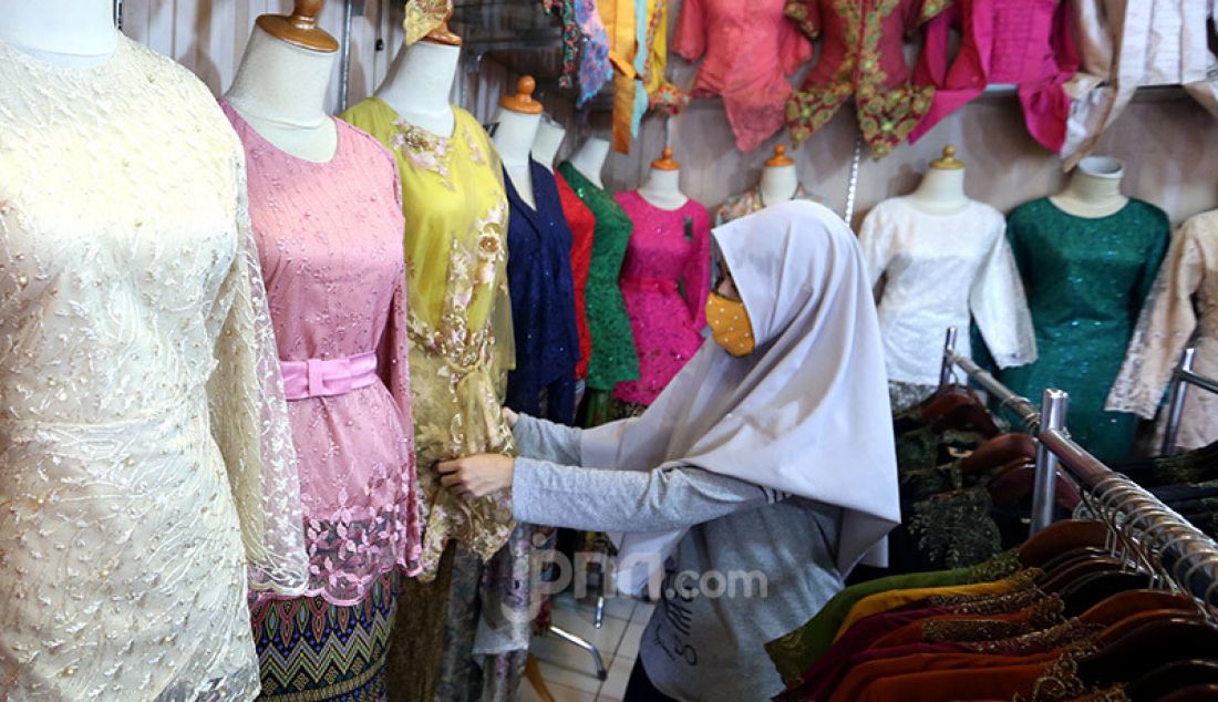 Pedagang membenahi display kebaya pada sebuah toko di sentra konveksi Bulak Timur, Depok, Senin (11/5). Penjualan saat ini mengalami penurunan drastis dari tahun lalu. - JPNN.com