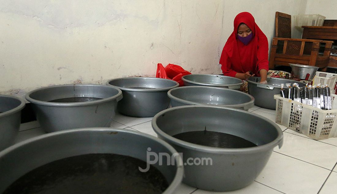 Pekerja mengemas pesanan dodol Betawi di pusat pembuatan dodol di kawasan Cilenggang, Serpong, Tangerang Selatan, Kamis (14/5). Dodol dijual dengan harga Rp 50.000 - Rp 70.000. - JPNN.com