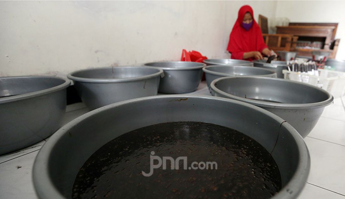 Pekerja mengemas pesanan dodol Betawi di pusat pembuatan dodol di kawasan Cilenggang, Serpong, Tangerang Selatan, Kamis (14/5). Dodol dijual dengan harga Rp 50.000 - Rp 70.000. - JPNN.com