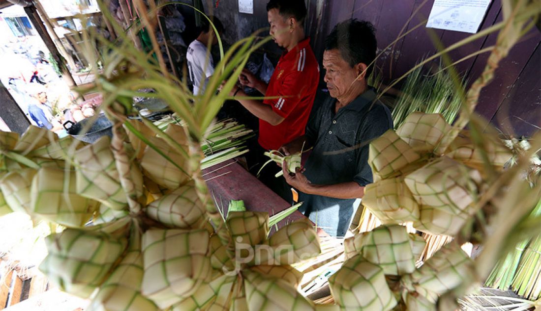 Pedagang membuat kulit ketupat di Pasar Gang Aut, Bogor, Jawa Barat, Jumat (15/5). Pedagang mengaku permintaan cangkang ketupat saat ini mengalami penurunan akibat pandemi Covid 19. - JPNN.com